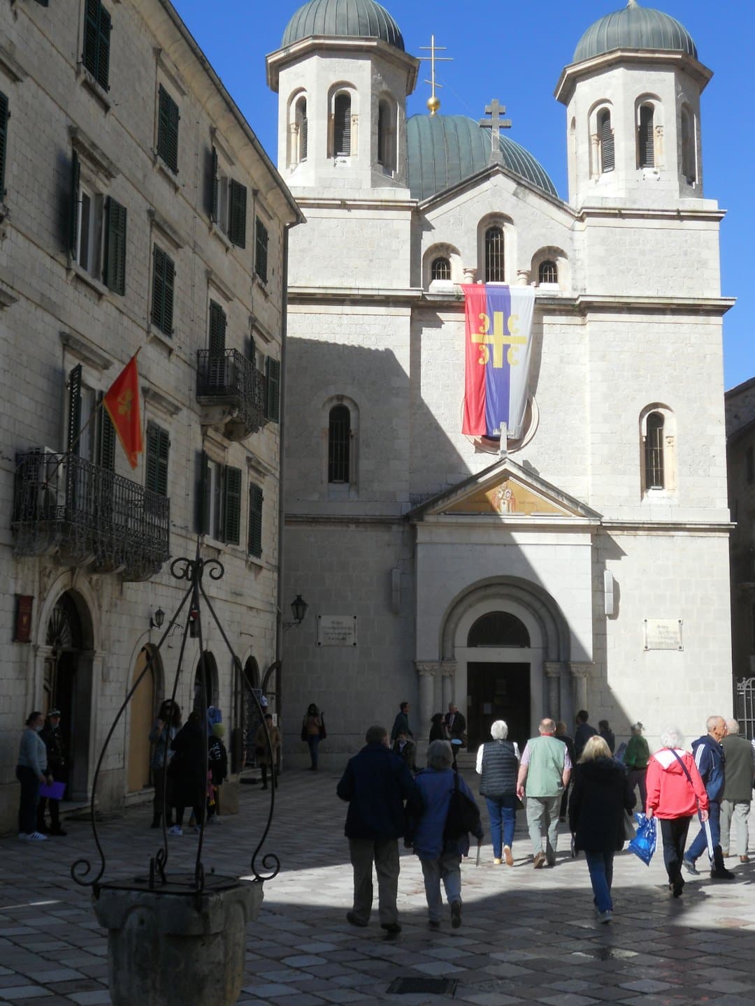 People walking toward a stone church with a large banner.